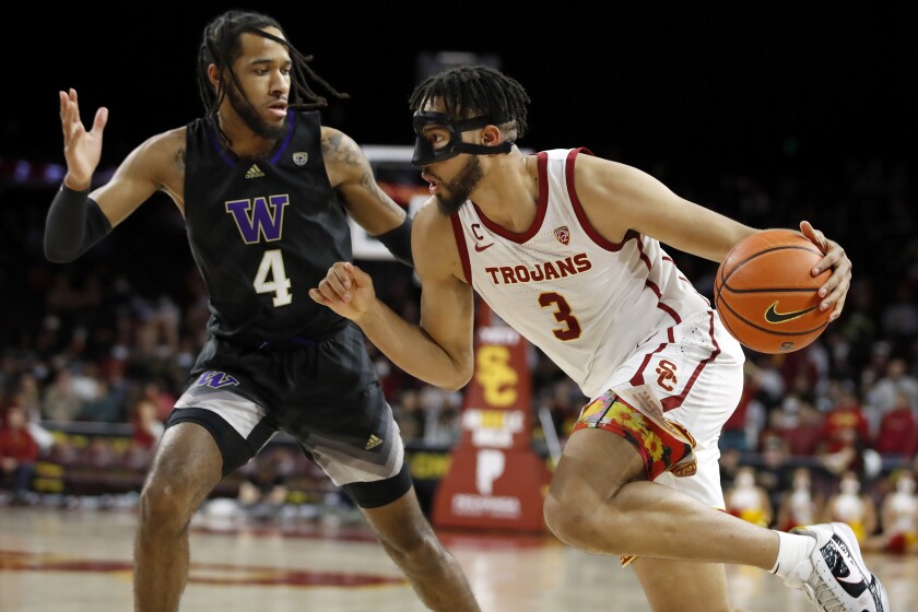 USC forward Isaiah Mobley drives past Washington guard PJ Fuller.