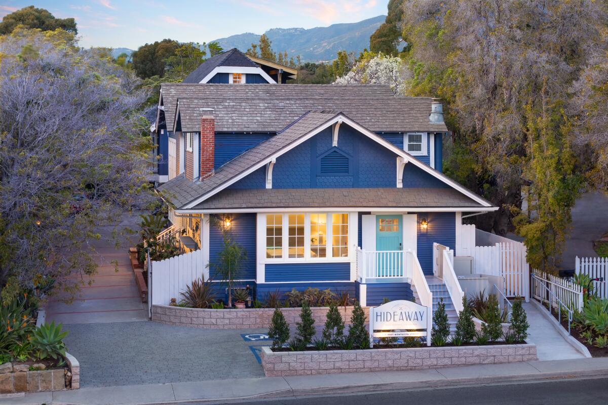 A blue Craftsman-style house with white trim