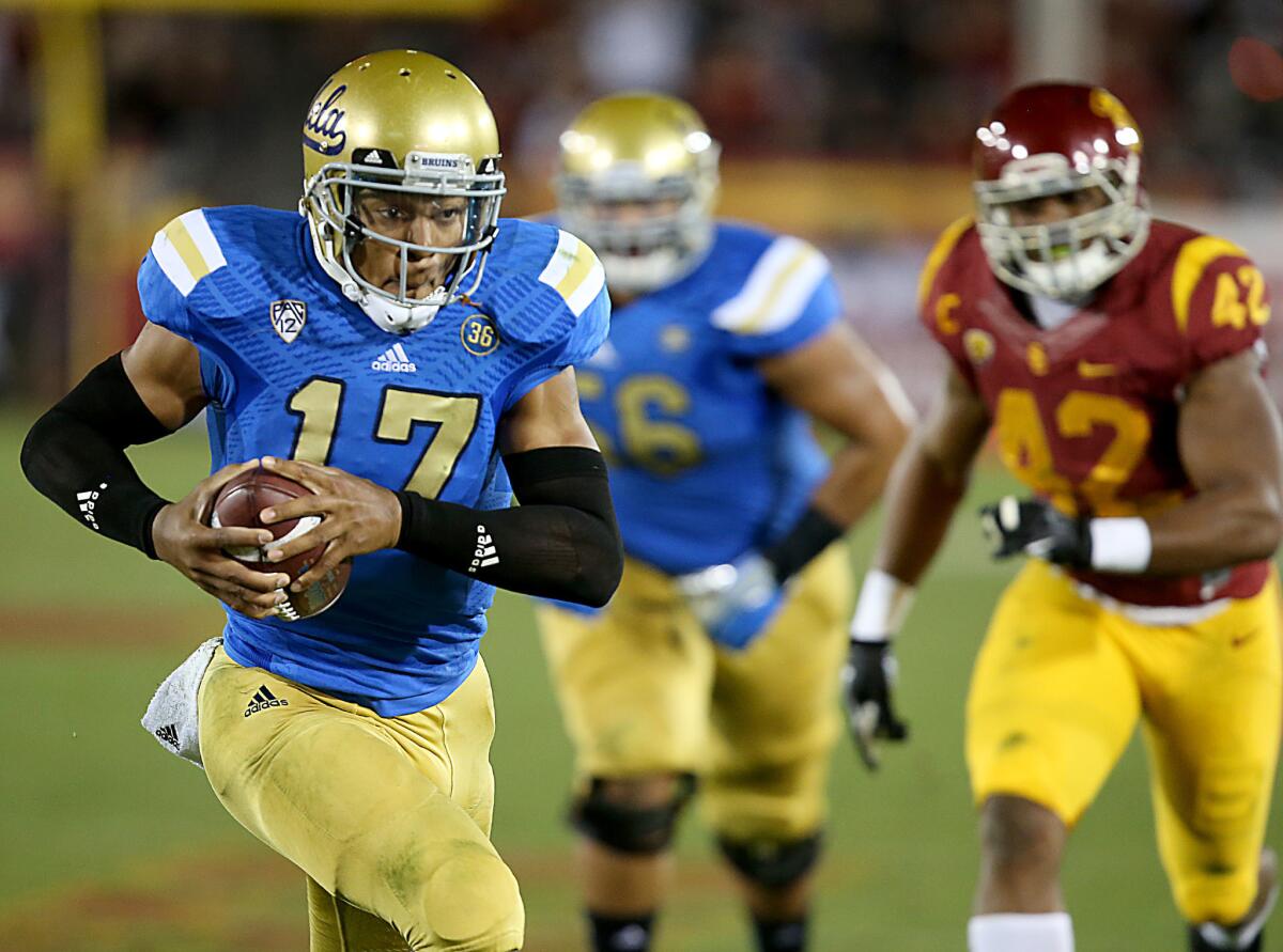 UCLA quarterback Brett Hundley runs for a touchdown against USC during a game at the Coliseum on Nov. 30, 2013.