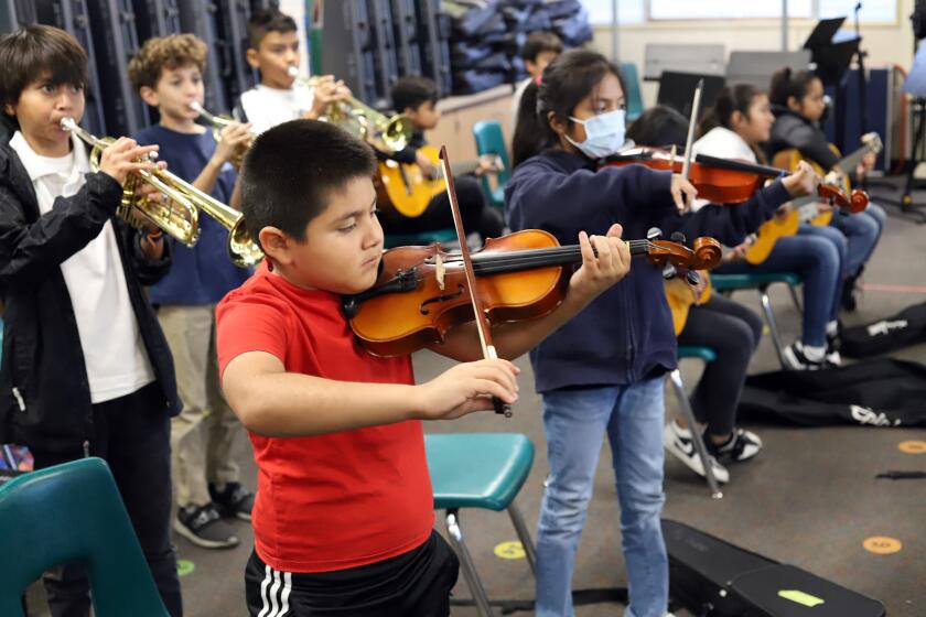 Students from Benjamin Franklin Elementary School learn how to play the mariachi classic "arboles de la barranca" by learning how to play the violin, trumpet and guitar during the Anaheim Elementary School District's, Learning Opportunities Program at Benjamin Franklin Elementary School in Anaheim on Tuesday, December 6, 2022. (Photo by James Carbone)
