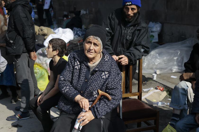 FILE - Ethnic Armenians from Nagorno-Karabakh sit next to their belongings near a tent camp after arriving to Armenia's Goris in Syunik region, Armenia, on Saturday, Sept. 30, 2023. A human rights organization representing ethnic Armenians has submitted evidence to the International Criminal Court arguing that Azerbaijan is committing an ongoing genocide against them. (AP Photo/Vasily Krestyaninov, File)