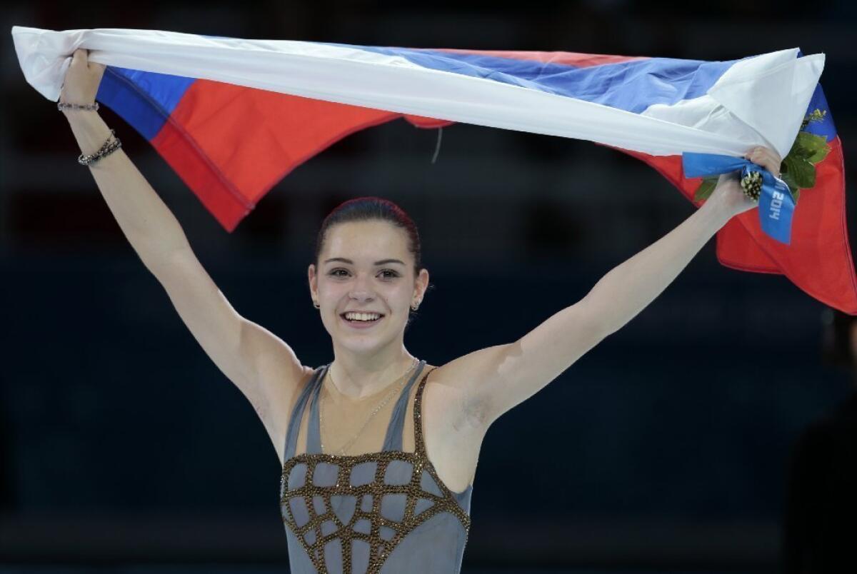 Adelina Sotnikova of Russia celebrates winning the women's free skate figure skating finals following the flower ceremony at the Iceberg Skating Palace.