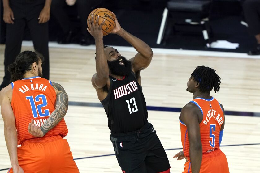 The Rockets' James Harden shoots over the Thunder's Luguentz Dort (5) and Steven Adams on Aug. 29, 2020.