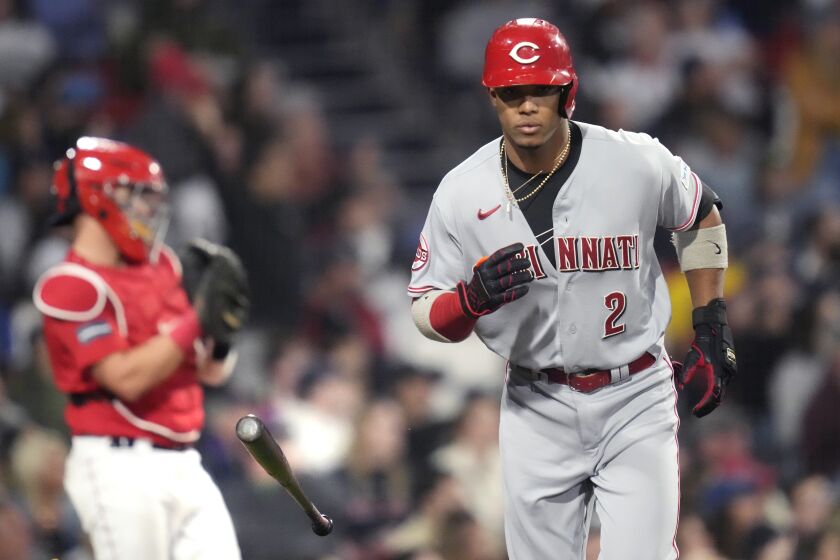 Cincinnati Reds' Jose Barrero (2) tosses his bat while heading down the first base line on his grand slam during the seventh inning of a baseball game at Fenway Park, Tuesday, May 30, 2023, in Boston. At left is Boston Red Sox catcher Reese McGuire. (AP Photo/Charles Krupa)