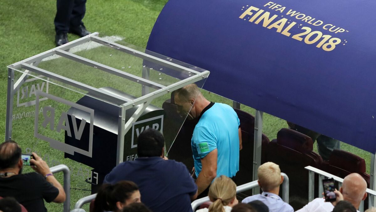 Referee Nestor Pitana reviews VAR footage before awarding France a penalty kick during the World Cup final on July 15.