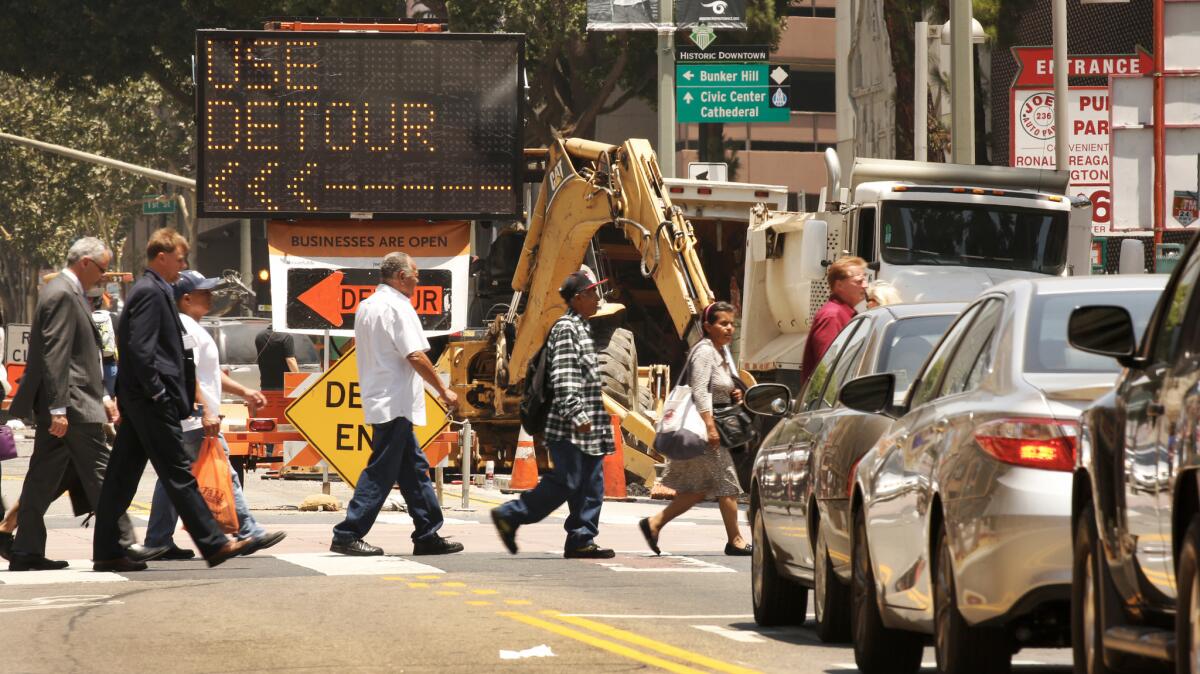 Signs warn of road closure at intersection of West 3rd Street and South Broadway in downtown Los Angeles, where a surge in construction has sparked what residents and commuters say is some of the worst traffic they can remember.