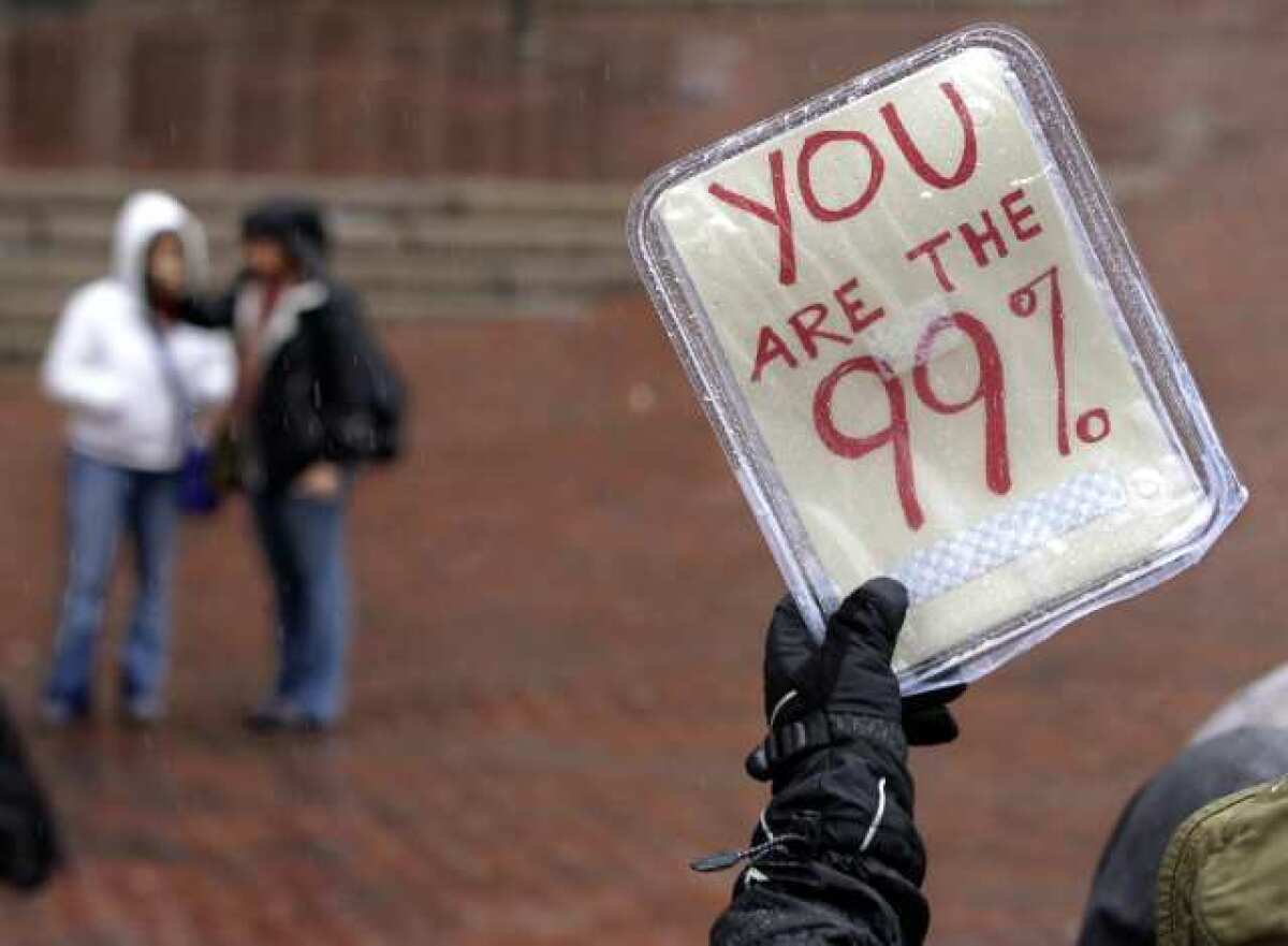 An Occupy supporter holds up a sign during a May Day in Boston. Occupy demonstrators across the country returned to the streets today to protest what they call corporate greed and government collusion.