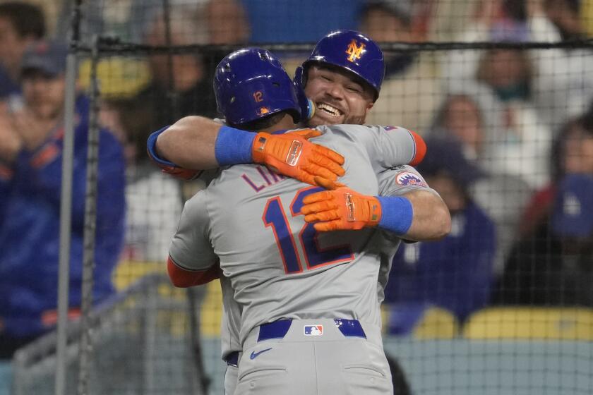 El boricua Francisco Lindor festeja con DJ Stewart, su compañero en los Mets, luego de conectar un jonrón ante los Dodgers de Los Ángeles, el viernes 19 de abril de 2024 (AP Foto/Ashley Landis)