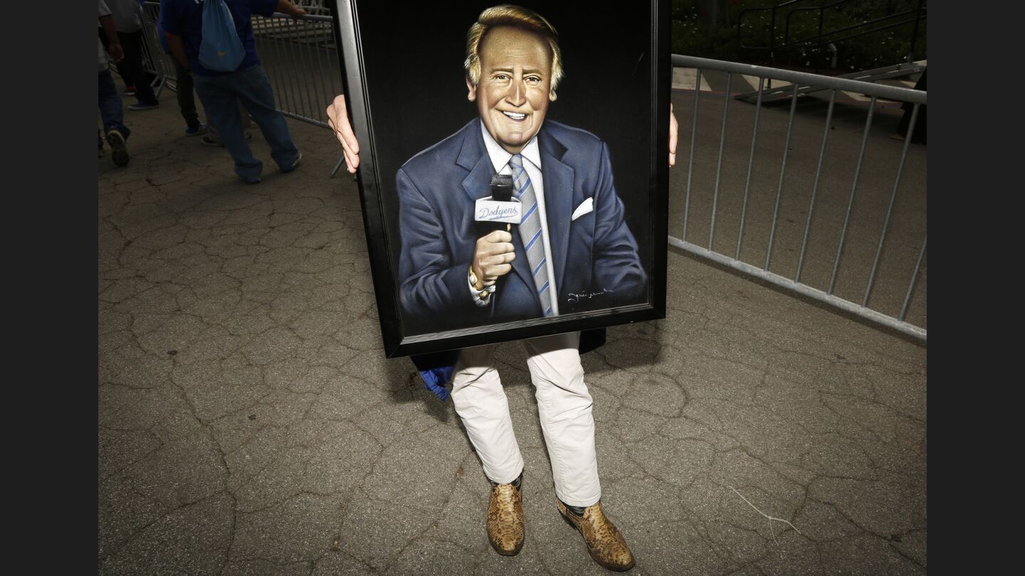 Dodgers fan Carl Baldwin holds a velvet painting of Vin Scully at the conclusion of the ceremony.