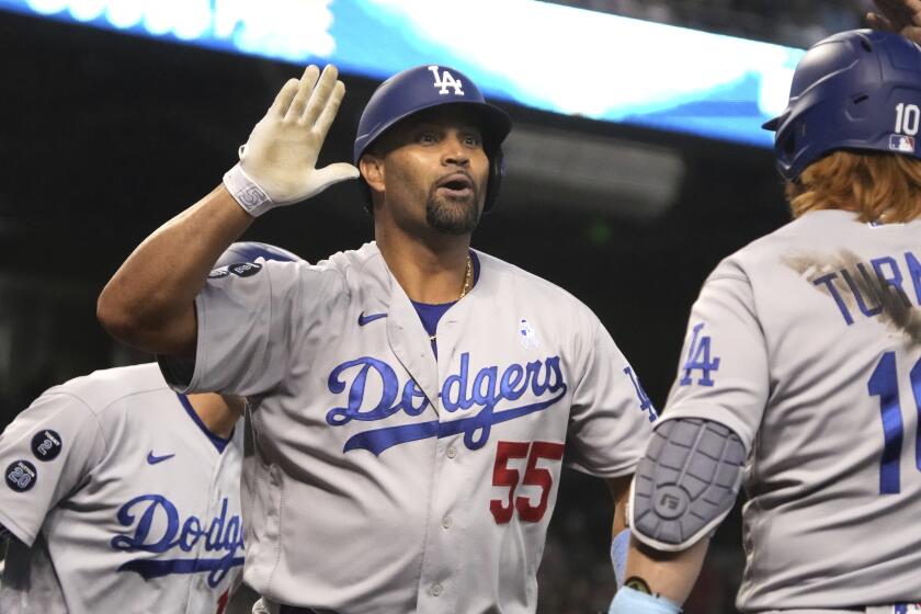 Los Angeles Dodgers' Albert Pujols (55) celebrates with Justin Turner after hitting a three-run home run.