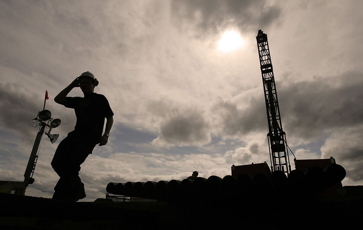 A Northern Dynasty Minerals Ltd. employee works by a core-sample drill rig at the proposed Pebble Mine site in Alaska.