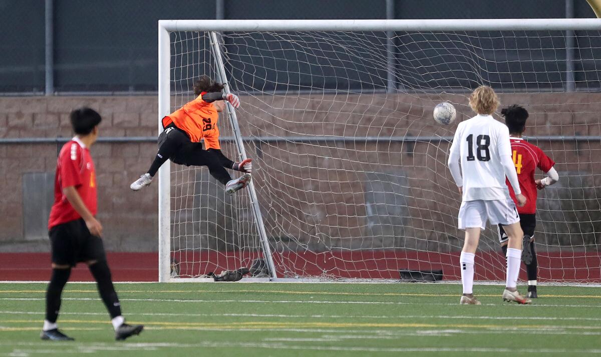 Marina goalkeeper Tanner Gill (29) leaps to stop a shot by Ocean View's Gabriel Castellanos that goes in for a score.