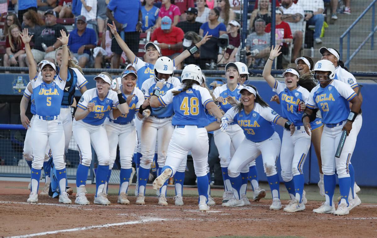 The UCLA softball team celebrates a home run against Oklahoma in the Women's College World Series in June.
