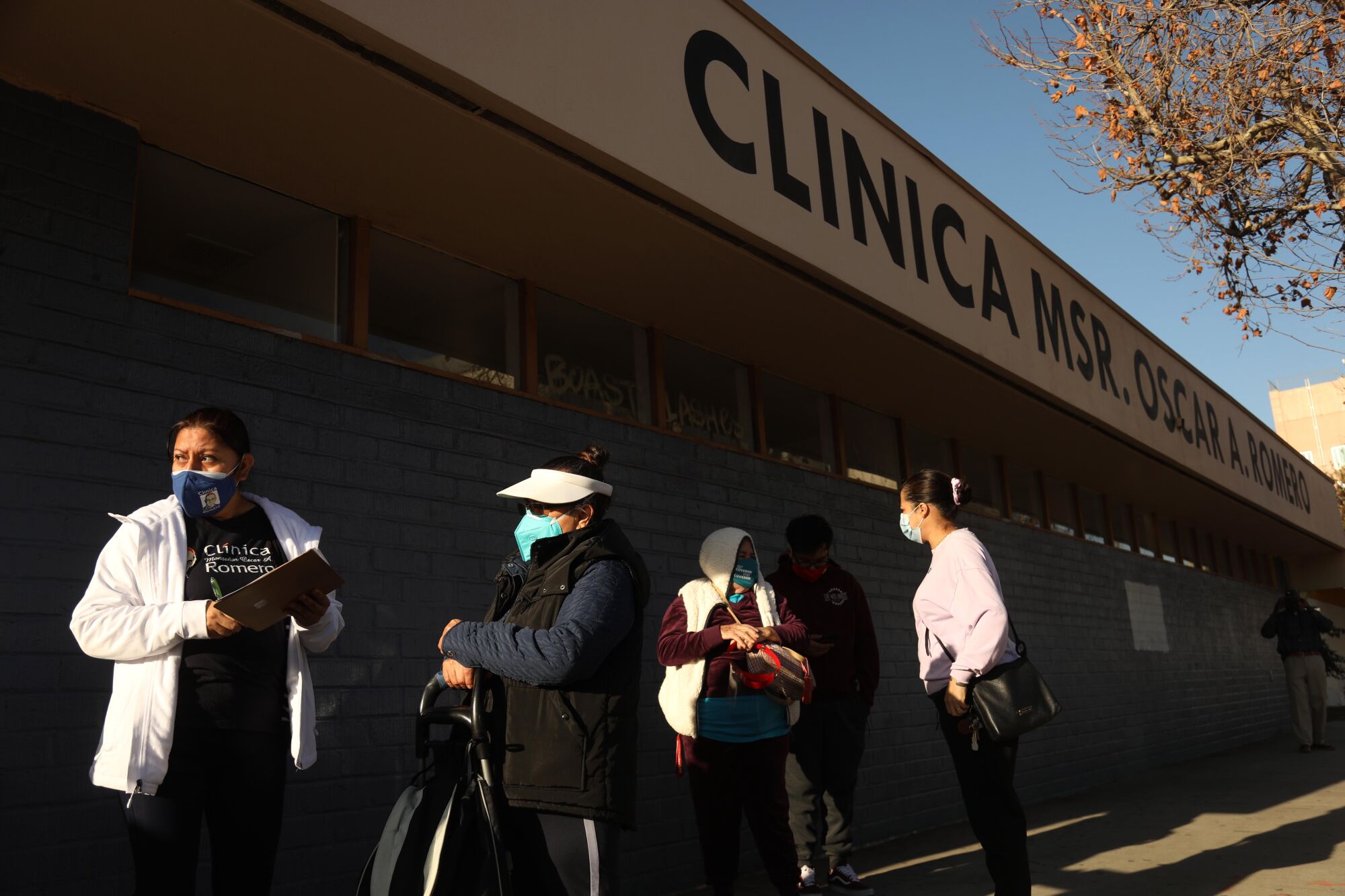  A staff member of Clínica Romero, left, registers patients at a COVID-19 vaccination clinic.