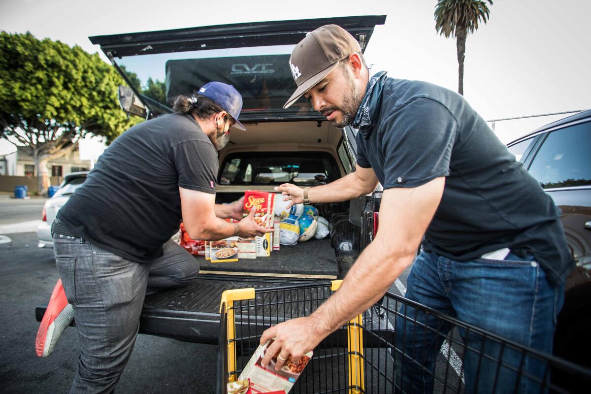 Former Dodgers outfielder Andre Ethier, right, helps load food into the back of a truck.