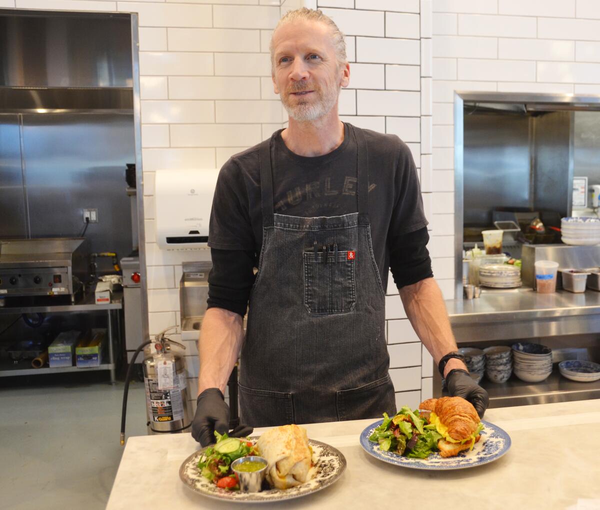 Head chef Daniel Hyatt serves a breakfast burrito, left, and egg croissant sandwich.