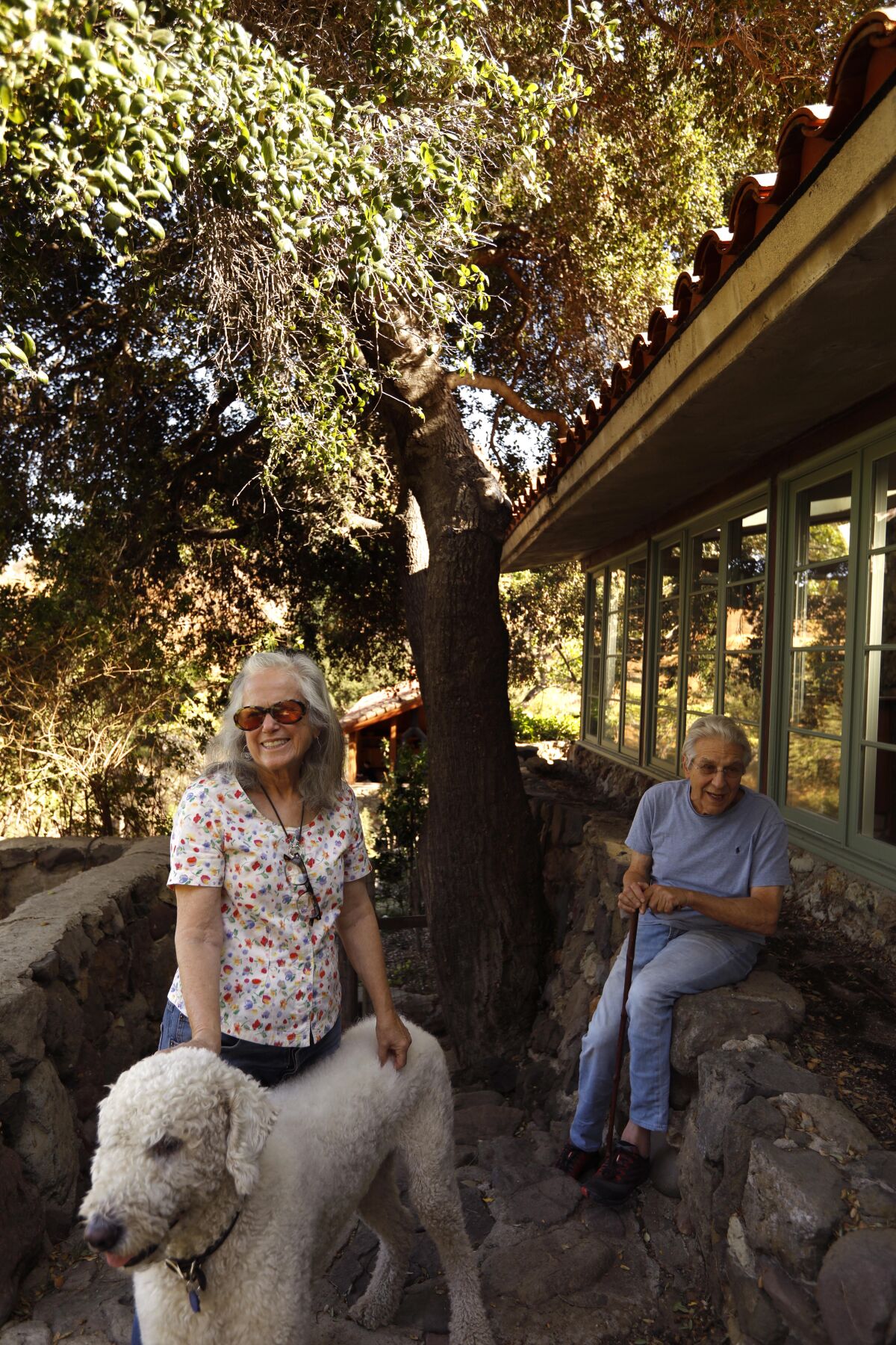 Leah and Paul Culberg, with Louie, believe the oaks they planted 40 years ago are "fire catchers" that saved their 1920s-era ranch house from burning in the Woolsey fire.