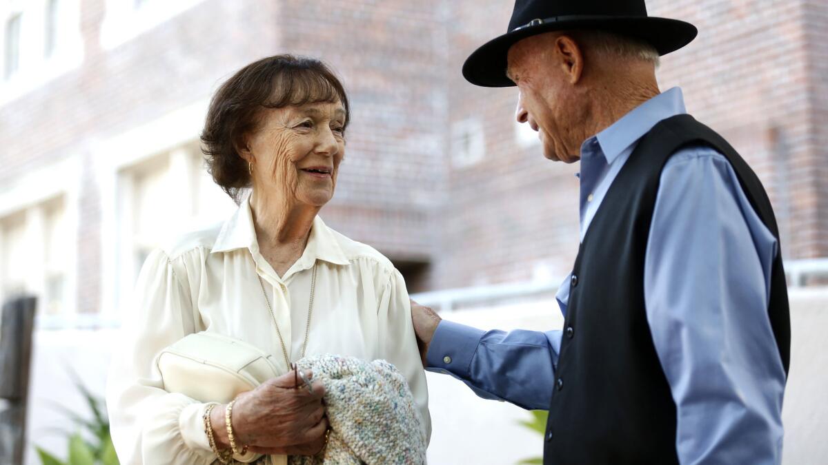 Beverly Sutton chats with Rolland Brous before the John Marshall High School Athletic Hall of Fame ceremony.