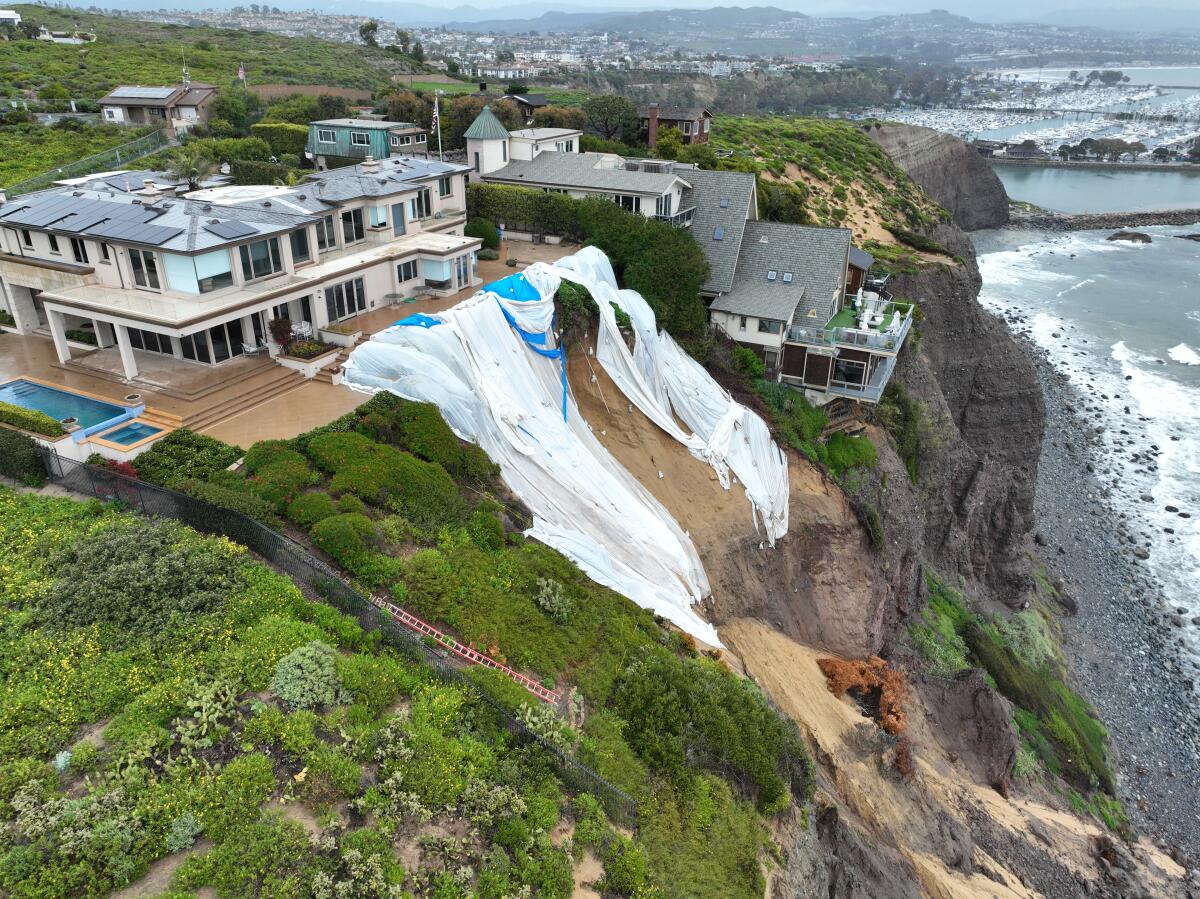 An aerial view of tarps next to cliffside houses.