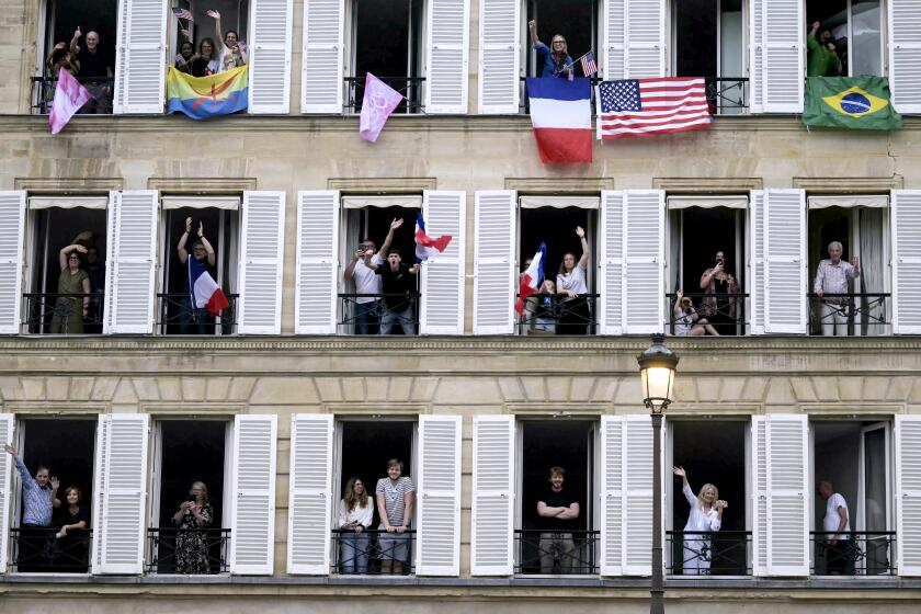 Spectators with various international flags cheering on from their balconies are pictured from the boat of Brazil's delegation sailing on the river Seine during the opening ceremony for the 2024 Summer Olympics in Paris, France, Friday, July 26, 2024. (Carl de Souza/Pool Photo via AP)