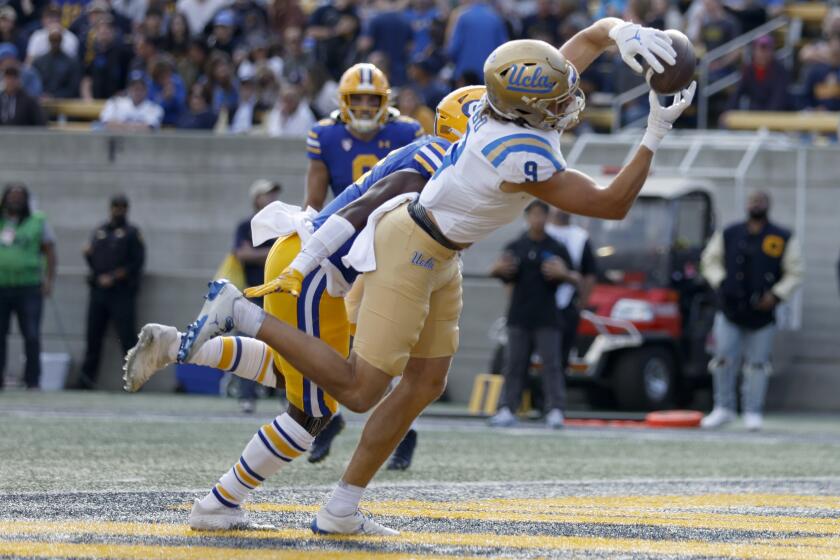 UCLA wide receiver Jake Bobo (9) catches a touchdown in front of California safety Craig Woodson (2) during the first half of an NCAA college football game in Berkeley, Calif., Friday, Nov. 25, 2022. (AP Photo/Jed Jacobsohn)