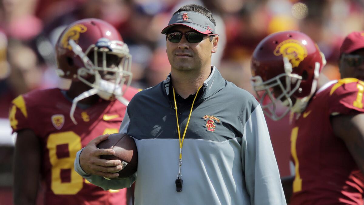 USC Coach Steve Sarkisian watches as his players warm up before the Trojans' spring game at the Coliseum on April 11.