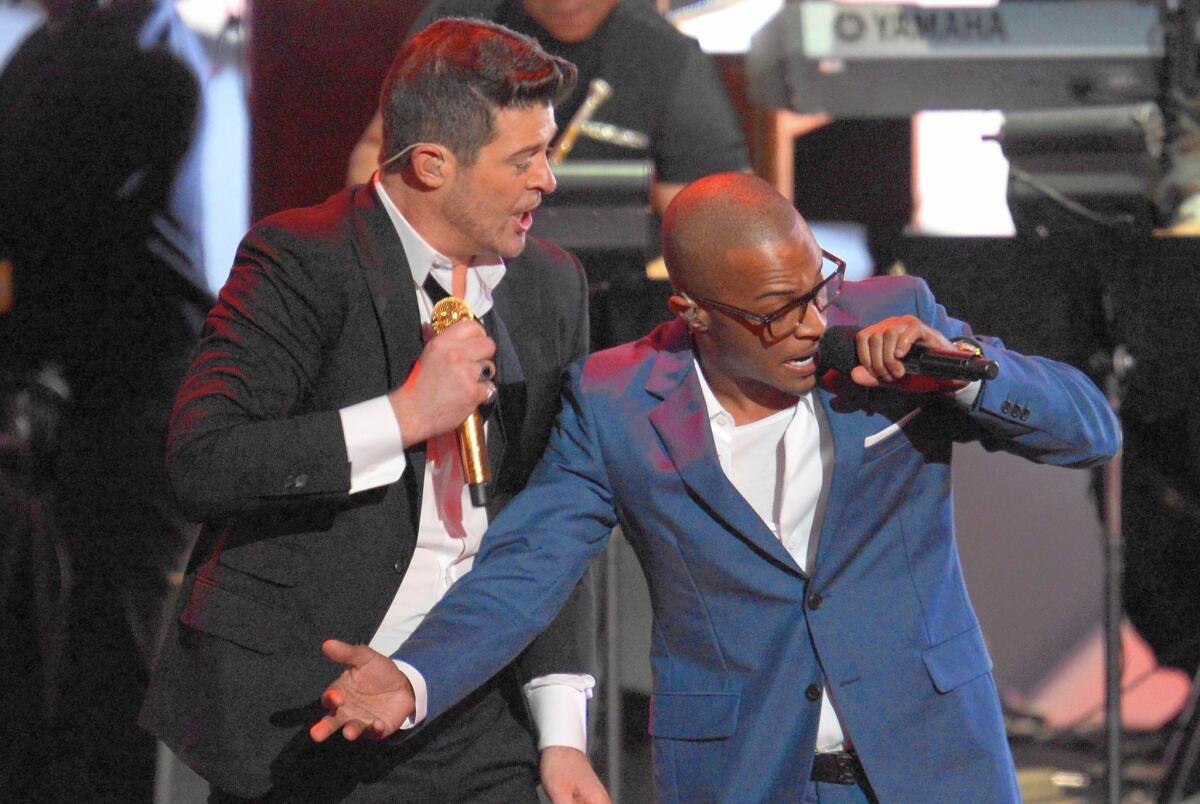 Robin Thicke (left) and T.I. perform the song "Blurred Lines" in Los Angeles on Dec. 6, 2013.