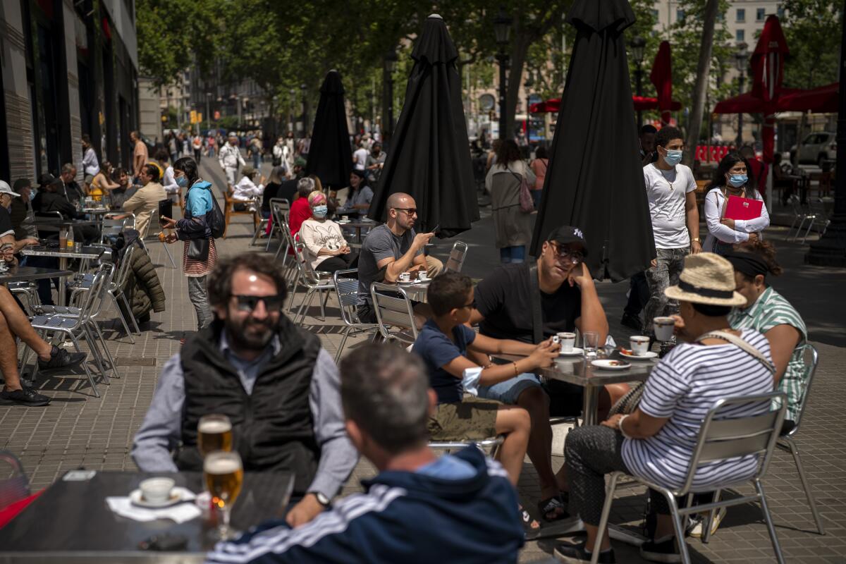 FILE - In this May 28, 2021, file photo, customers sit in a terrace bar in downtown Barcelona, Spain. Coronavirus infections, hospitalizations and deaths are plummeting across much of Europe. Vaccination rates are accelerating, and with them, the promise of summer vacations. (AP Photo/Emilio Morenatti, File)