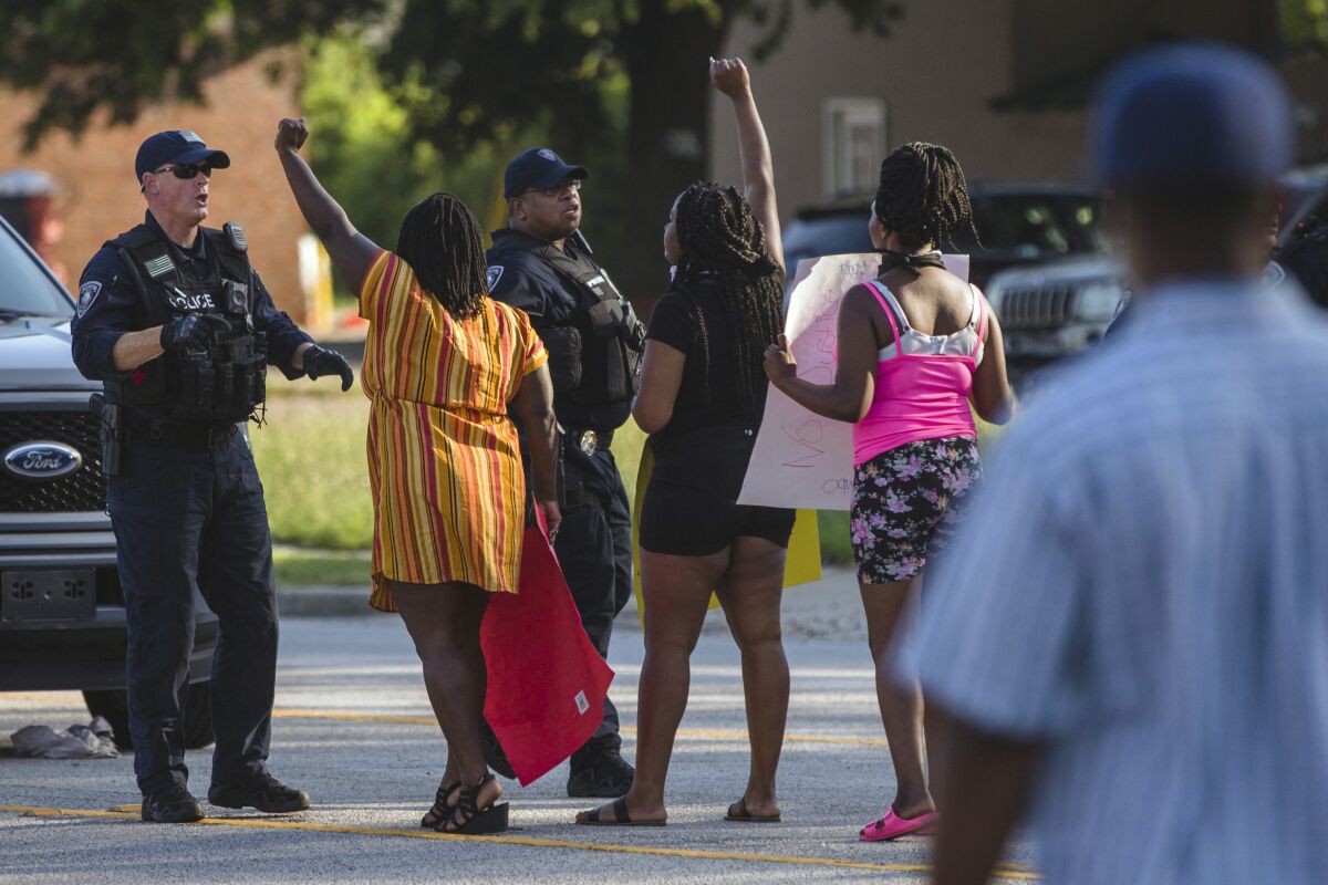 Brittany Martin, second from left, wearing striped clothing, confronts police before demonstrators in support of George Floyd march with an escort around downtown Sumter, S.C., on May 31, 2020. Martin, a pregnant Black activist serving four years in prison for her behavior at racial justice protests, is scheduled to have her sentence reconsidered as she struggles to reach her due date behind bars. (Micah Green/The Item via AP)