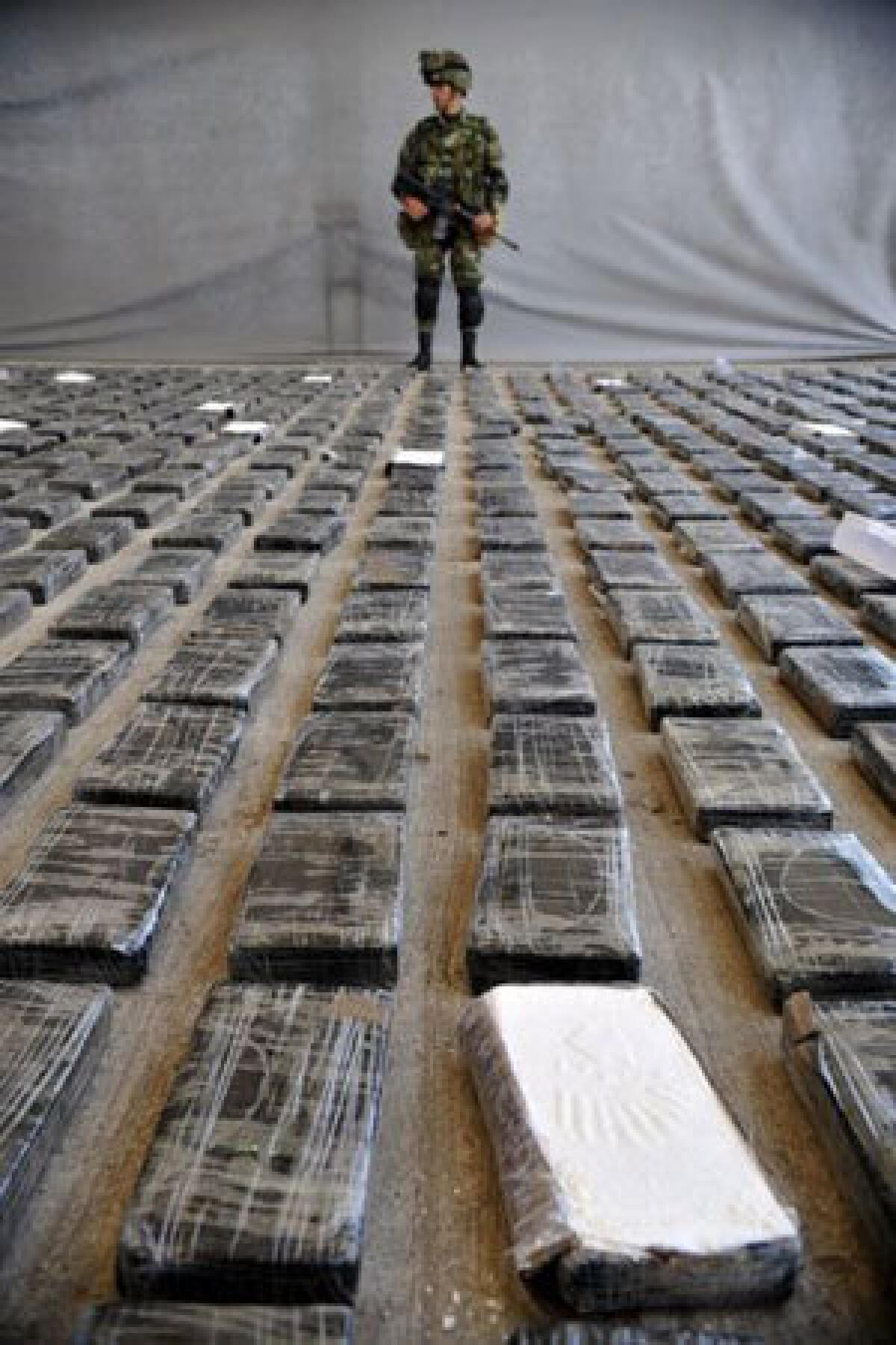A soldier guards cocaine seized in Colombia. Research shows that cocaine takes the brakes off the user's brain reward circuitry.