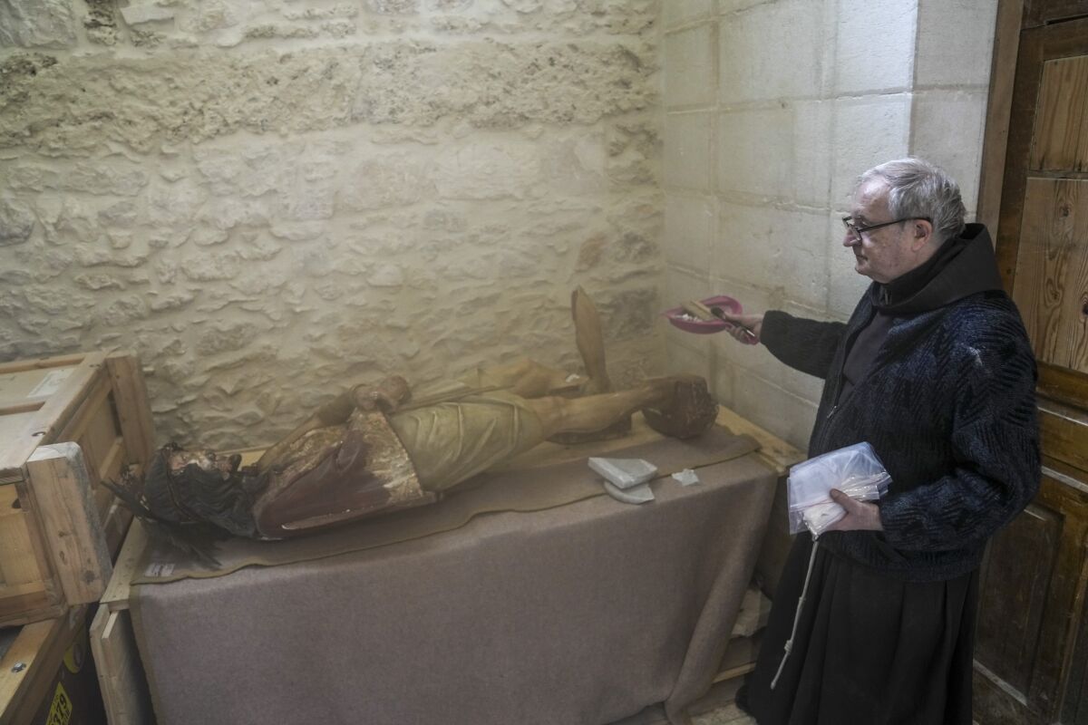 Un sacerdote junto a una imagen dañada de Jesús en la iglesia de la Flagelación en la Ciudad Vieja de Jerusalén