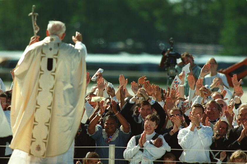 Pope John Paul II acknowledges a crowd after the conclusion of Mass at Aqueduct Race Track in Queens, N.Y., in 1995.