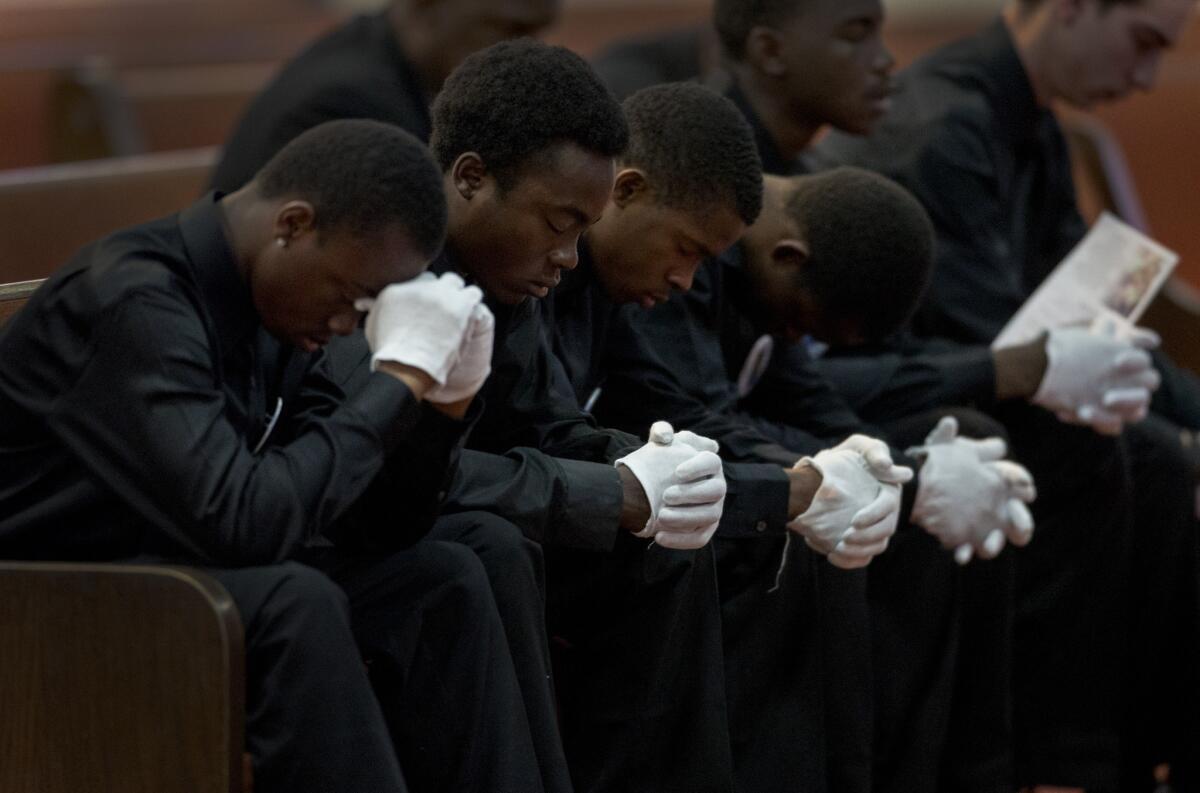 Pallbearers at the funeral of 12-year-old Jason Spears bow their heads in prayer at his funeral at Ecclesia Christian Fellowship in San Bernardino.