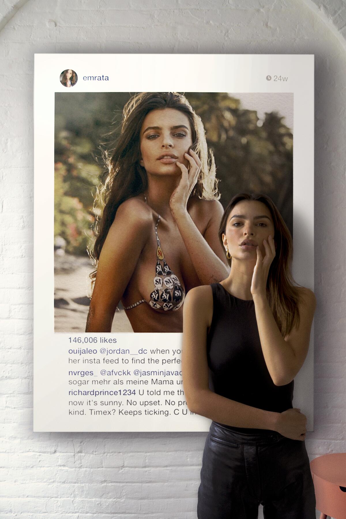 Emily Ratajkowski stands in front of a photo of herself.