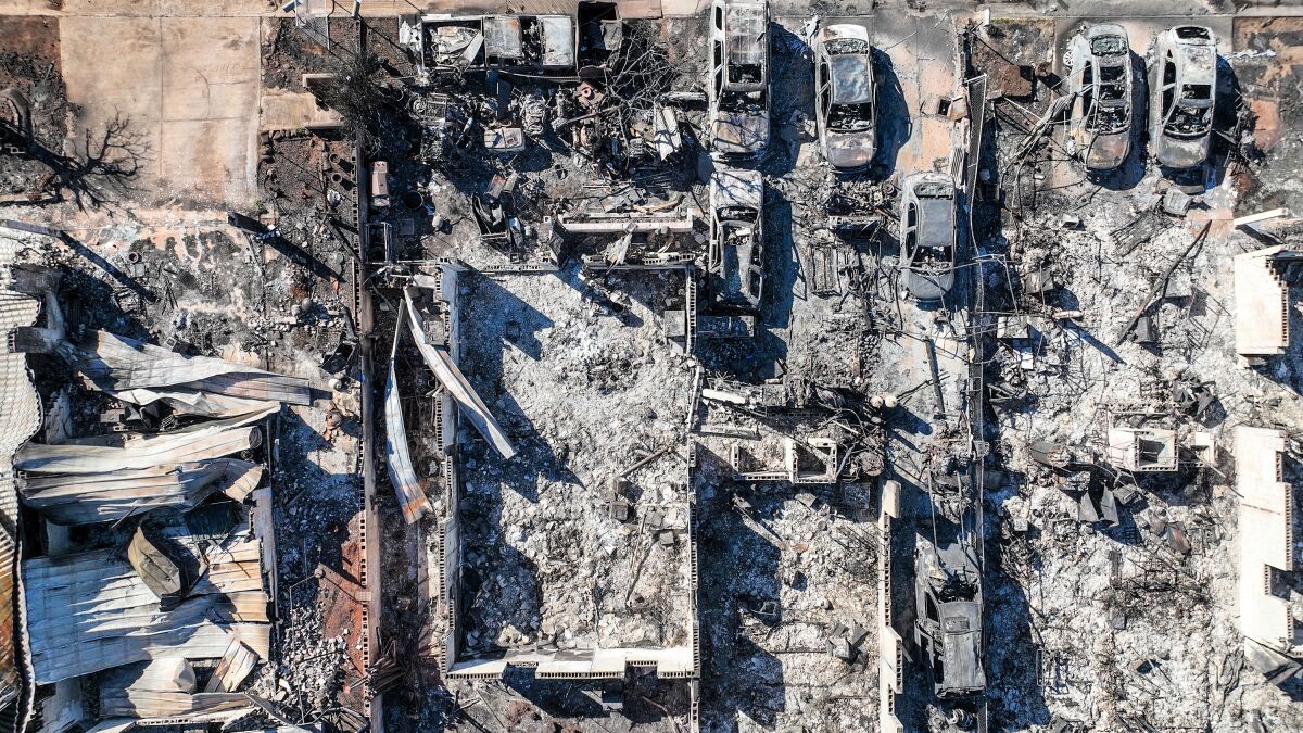 Aerial photographs show homes and businesses in ruins after a wildfire.
