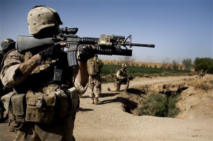 In this photo taken Friday, March 19, 2010, Lance Cpl. Ruben Herrera of Memphis, Tenn., with the First Battalion, Sixth Marine Regiment, Alpha company, scans the area with his M-16 rifle in Marjah, Afghanistan. The U.S. military's workhorse rifle, used in battle for the last 40 years, is proving less effective in Afghanistan, where the Taliban's more primitive but longer range weapons can threaten NATO forces at distances too great for American soldiers to return fire effectively. (AP Photo/Dusan Vranic)