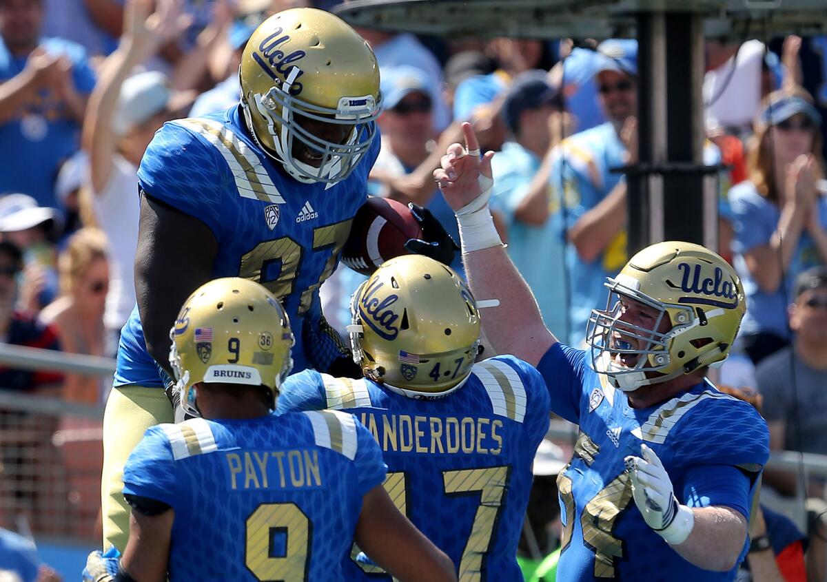 UCLA defensive lineman Kenny Clark (97) is congratulated by teammates after scoring a touchdown on a pass play against Virginia in the second half on Sept. 5.