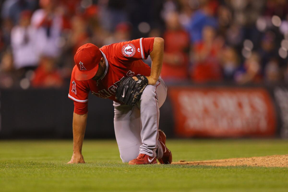 Angeles closer Huston Street doubles over after appearing to injure himself on the final out of the game against the Rockies.