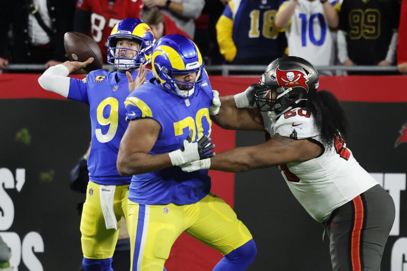 TAMPA BAY, FL- JANUARY 23, 2022: Los Angeles Rams quarterback Matthew Stafford (9) unleashes a 44-yard pass to Los Angeles Rams wide receiver Cooper Kupp (10) to set up the game winning field goal to beat the Buccaneers 30-27 in the NFC Divisional game at Raymond James Stadium on January 23, 2022 in Tampa Bay, Florida. Los Angeles Rams offensive tackle Joe Noteboom (70) holds off Tampa Bay Buccaneers nose tackle Vita Vea (50). (Gina Ferazzi / Los Angeles Times)