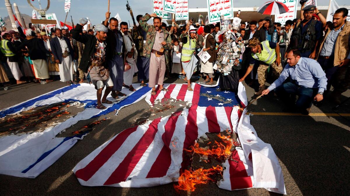 Supporters of Yemen's Houthi rebels burn U.S. and Israeli flags at a protest in Sana on May 20, the day President Trump began a visit to Saudi Arabia.
