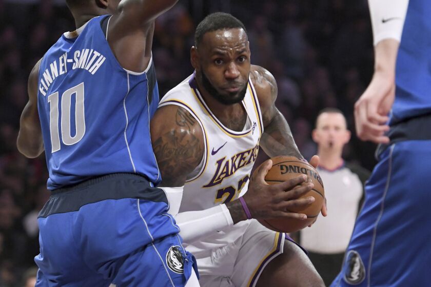 Los Angeles Lakers guard LeBron James drives to the basket against Dallas Mavericks forward Dorian Finney-Smith, left, during the first half of an NBA basketball game Sunday, Dec. 29, 2019, in Los Angeles. (AP Photo/Michael Owen Baker)