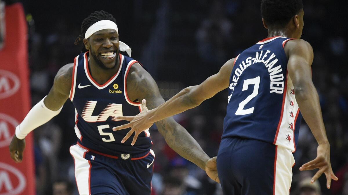 Clippers forward Montrezl Harrell (5) celebrates with guard Shai Gilgeous-Alexander after making a basket during the first half Saturday.