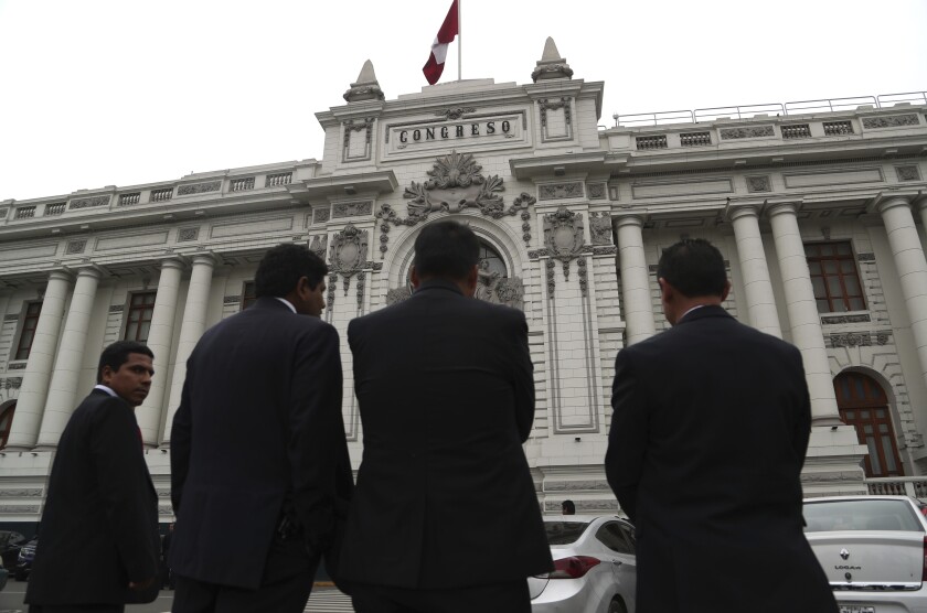 FILE - In this Sept. 30, 2019 file photo, security officers stand outside Congress where lawmakers are expected to push forward a vote to select an almost-full slate of new magistrates to the Constitutional Tribunal, in Lima, Peru. Peru’s Constitutional Court has backed President Martín Vizcarra’s controversial decision to dissolve the nation’s legislature in 2019, with magistrates voting on Jan. 14, 2020 to ratify Vizcarra’s move and dismiss a complaint backed by opposition lawmakers. (AP Photo/Martin Mejia, File)