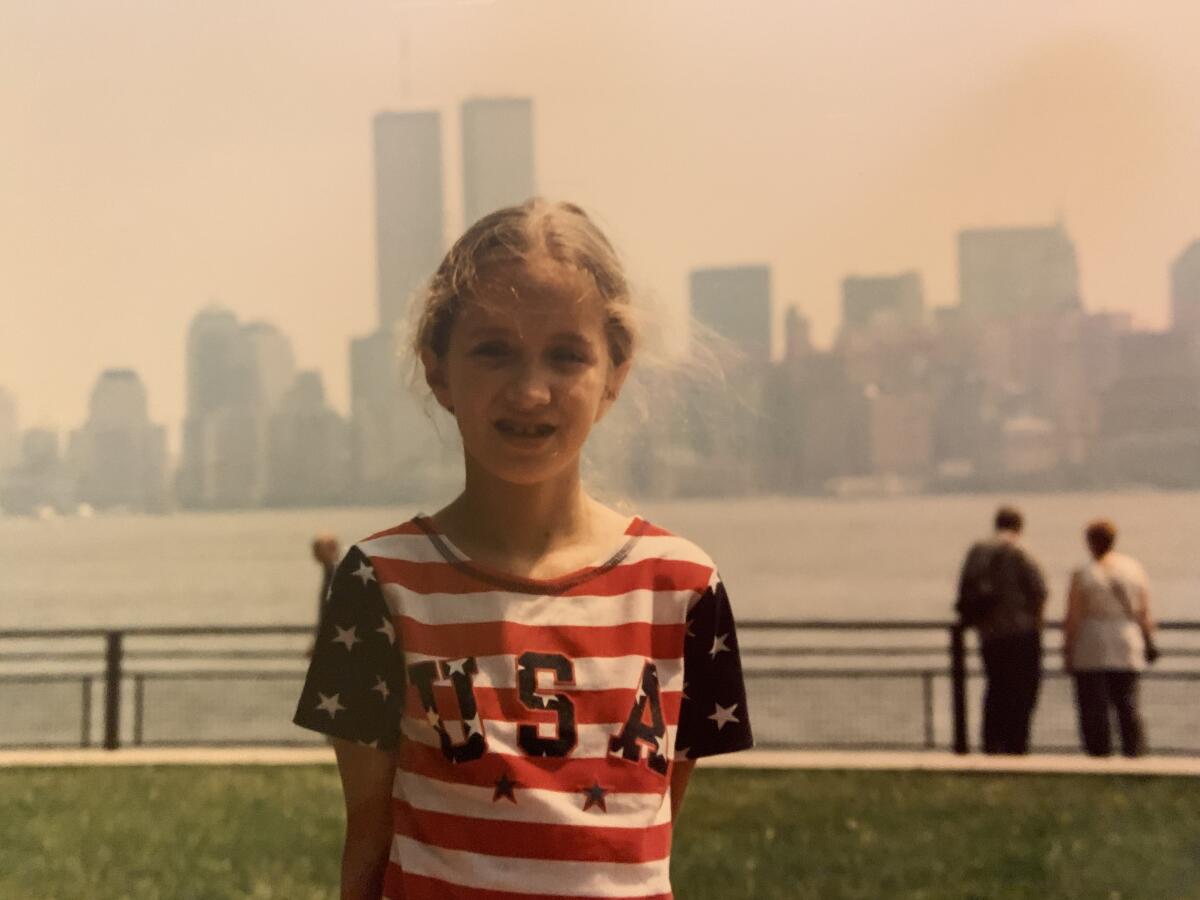 A girl in an American flag shirt, with Twin Towers in background