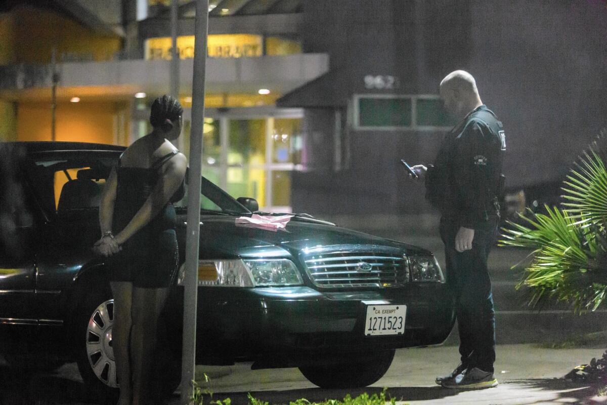 A police officer questions a girl in a South Los Angeles area known for sex trafficking involving minors.