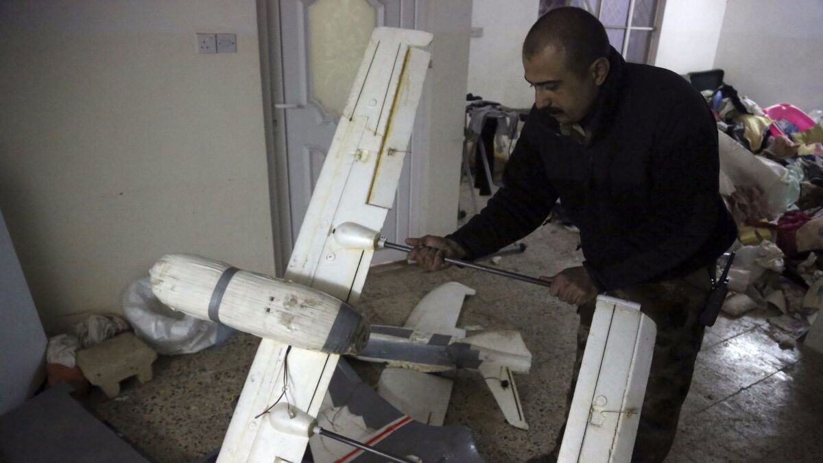 An Iraqi officer in Mosul inspects a drone that belonged to Islamic State militants.