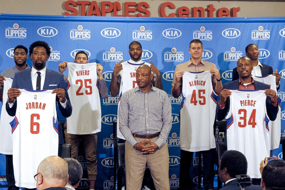 Los Angeles Clippers Coach Doc Rivers, center, stands with off-season signees, from left, Branden Dawson, DeAndre Jordan, Austin Rivers, Josh Smith, Cole Aldrich, Paul Pierce and Wesley Johnson at a news conference on Tuesday.