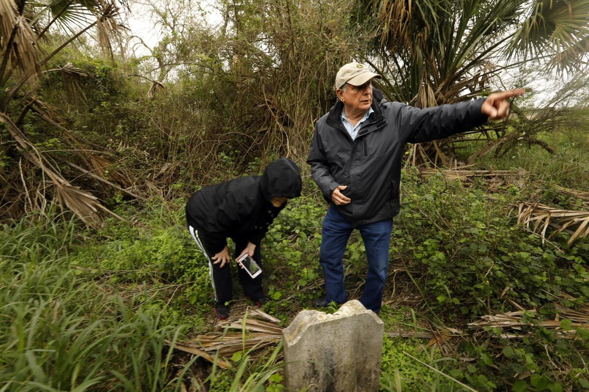 Juan Granado, 73, and his wife, Esmeralda, 69, look at gravestones in a cemetery not far from their home in Brownsville, Texas. It was the first time they were allowed to visit the cemetery in a decade.