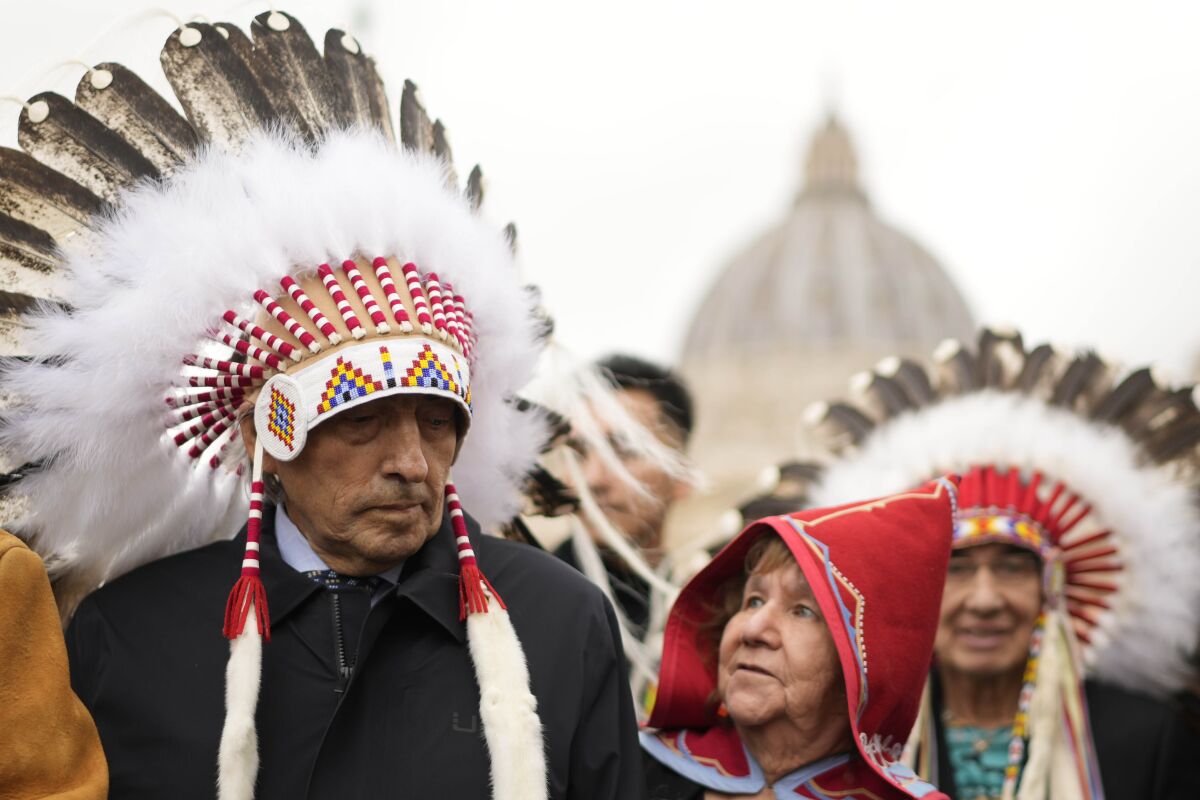 Indigenous people standing outside St. Peter's Square