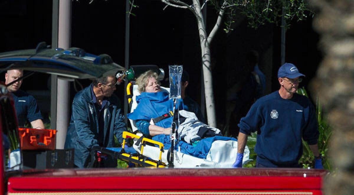 A woman is taken to a paramedic truck from an office building where a shooter opened fire in north central Phoenix.